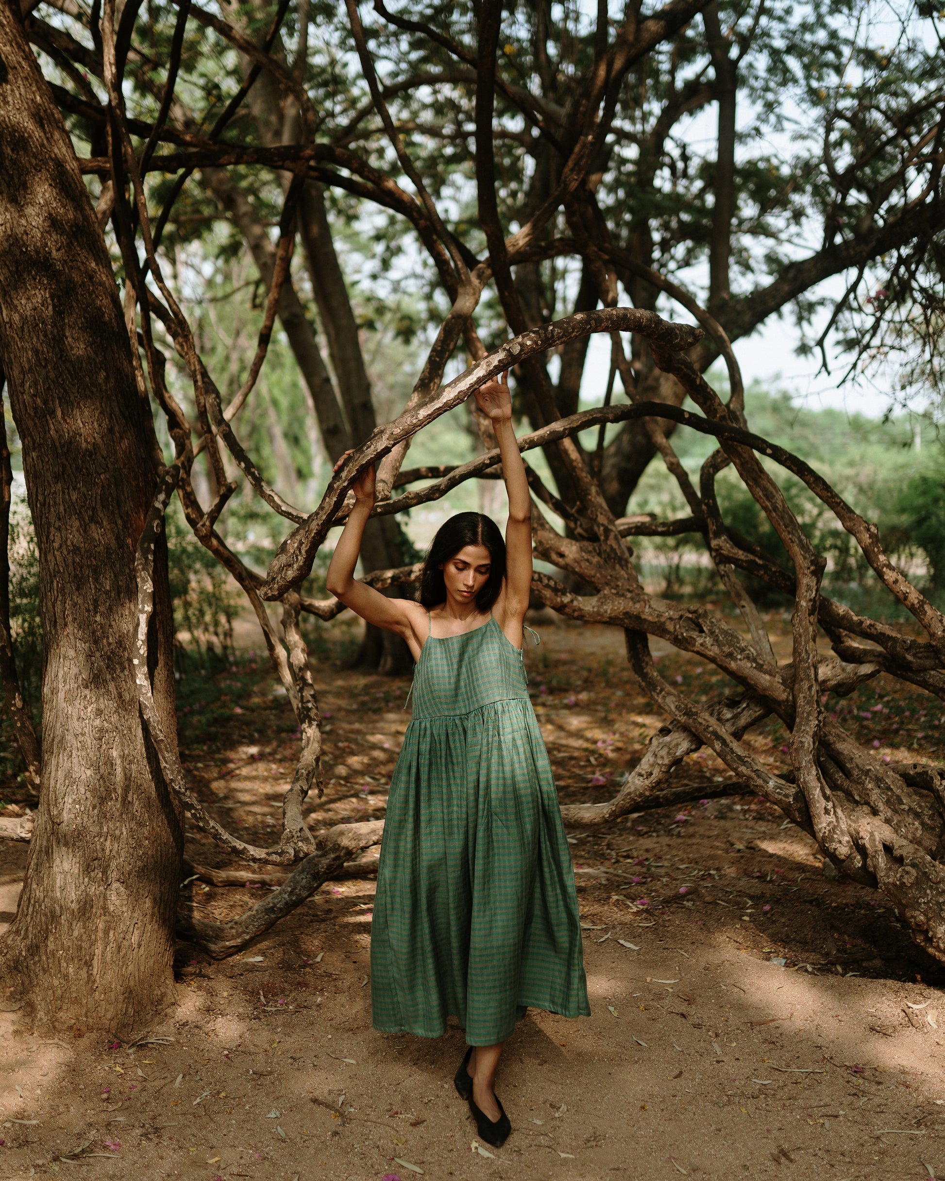 Plains Design - River mulberry silk cotton dress. Sleeveless midi dress with spaghetti straps, and a gathered waist in a green cotton mulberry silk fabric with red and white checks. Ethically handmade and handspun in India.