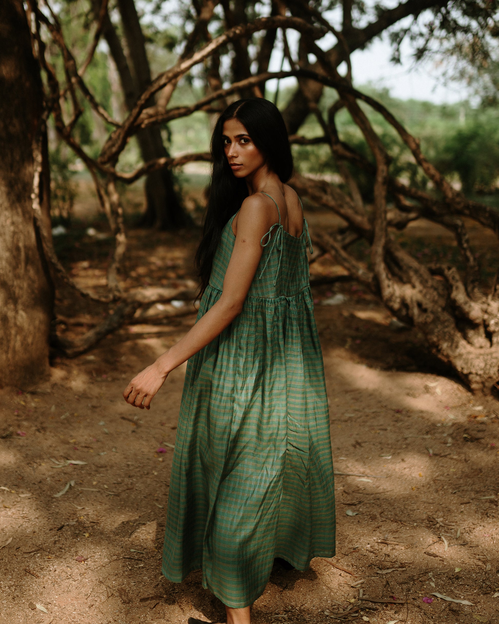 Plains Design - River mulberry silk cotton dress. Sleeveless midi dress with spaghetti straps, and a gathered waist in a green cotton mulberry silk fabric with red and white checks. Ethically handmade and handspun in India.