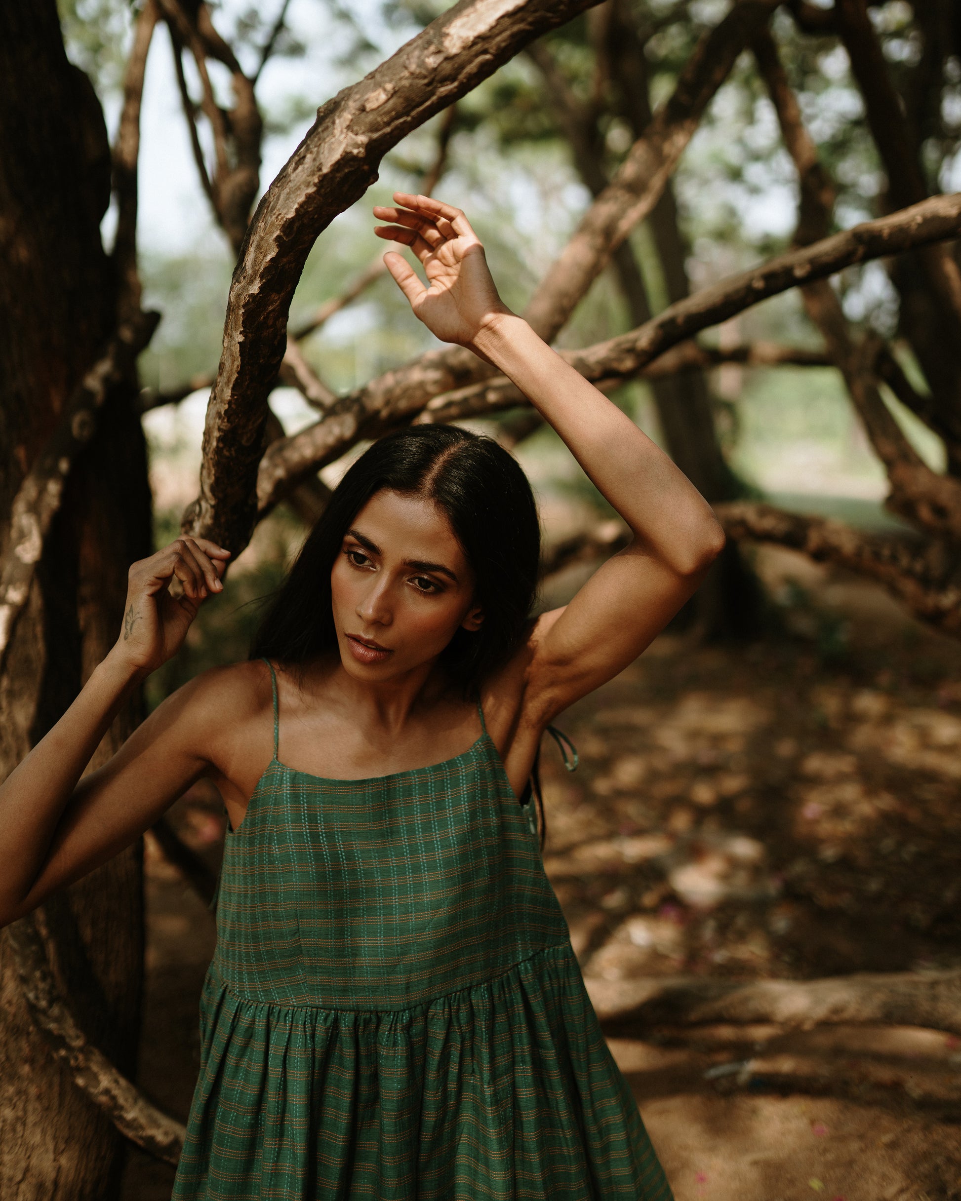 Plains Design - River mulberry silk cotton dress. Sleeveless midi dress with spaghetti straps, and a gathered waist in a green cotton mulberry silk fabric with red and white checks. Ethically handmade and handspun in India.