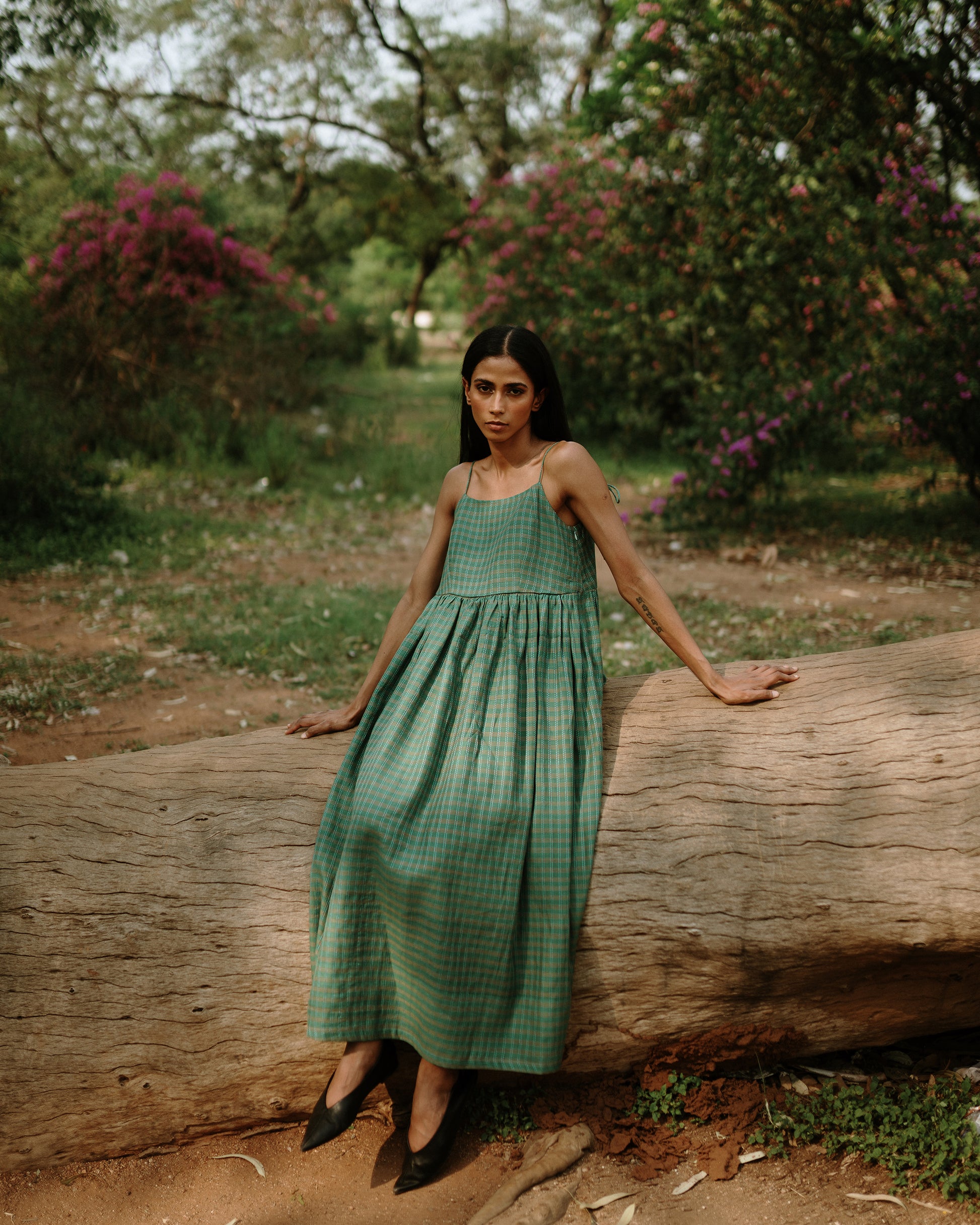 Plains Design - River mulberry silk cotton dress. Sleeveless midi dress with spaghetti straps, and a gathered waist in a green cotton mulberry silk fabric with red and white checks. Ethically handmade and handspun in India.