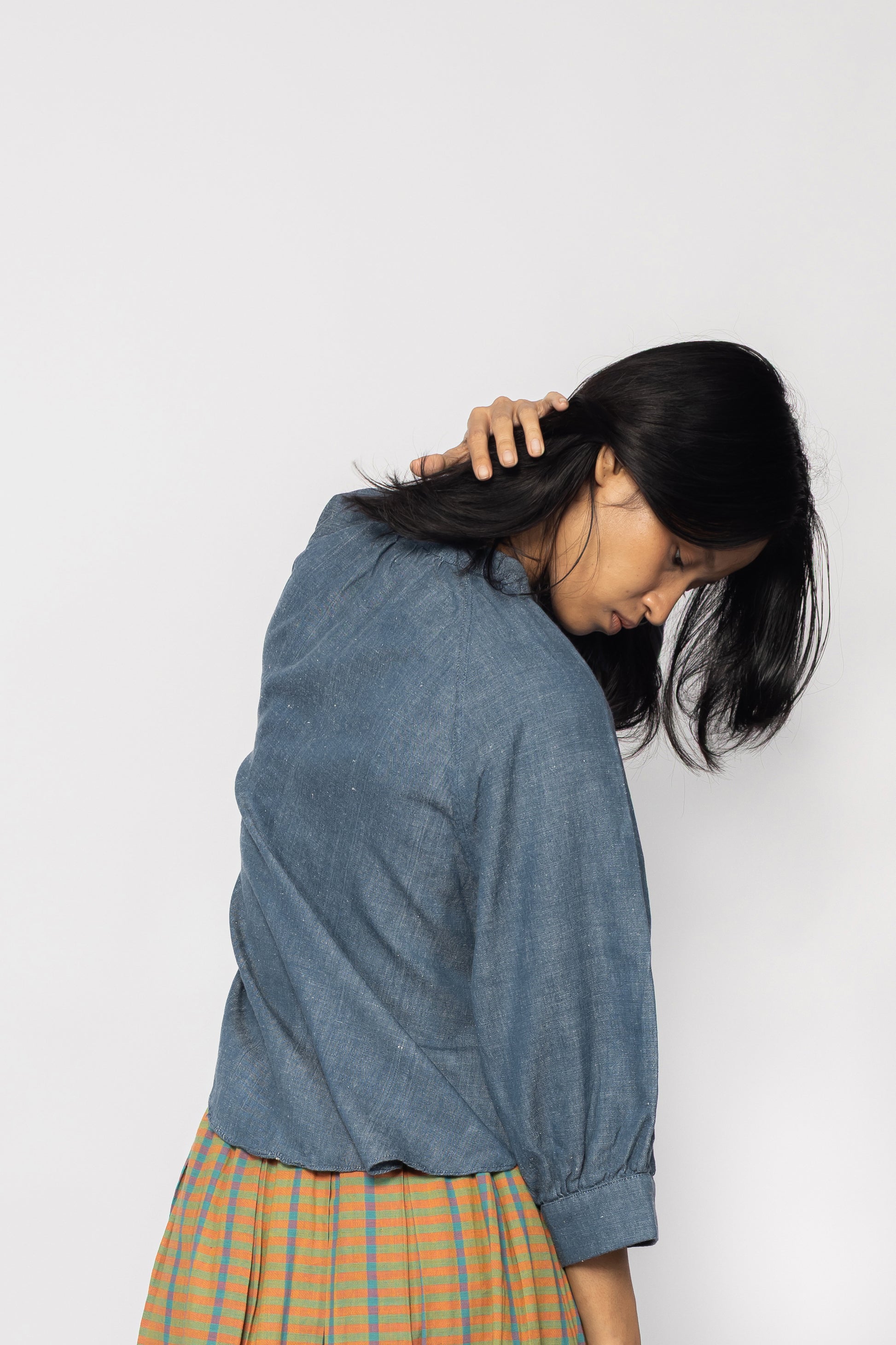 Plains Design - Sault wide sleeved top. Back of denim wide sleeved top in a relaxed fit. Three quarter sleeves. Paired with an orange skirt. Ethically handmade in India with handspun cotton twill denim.