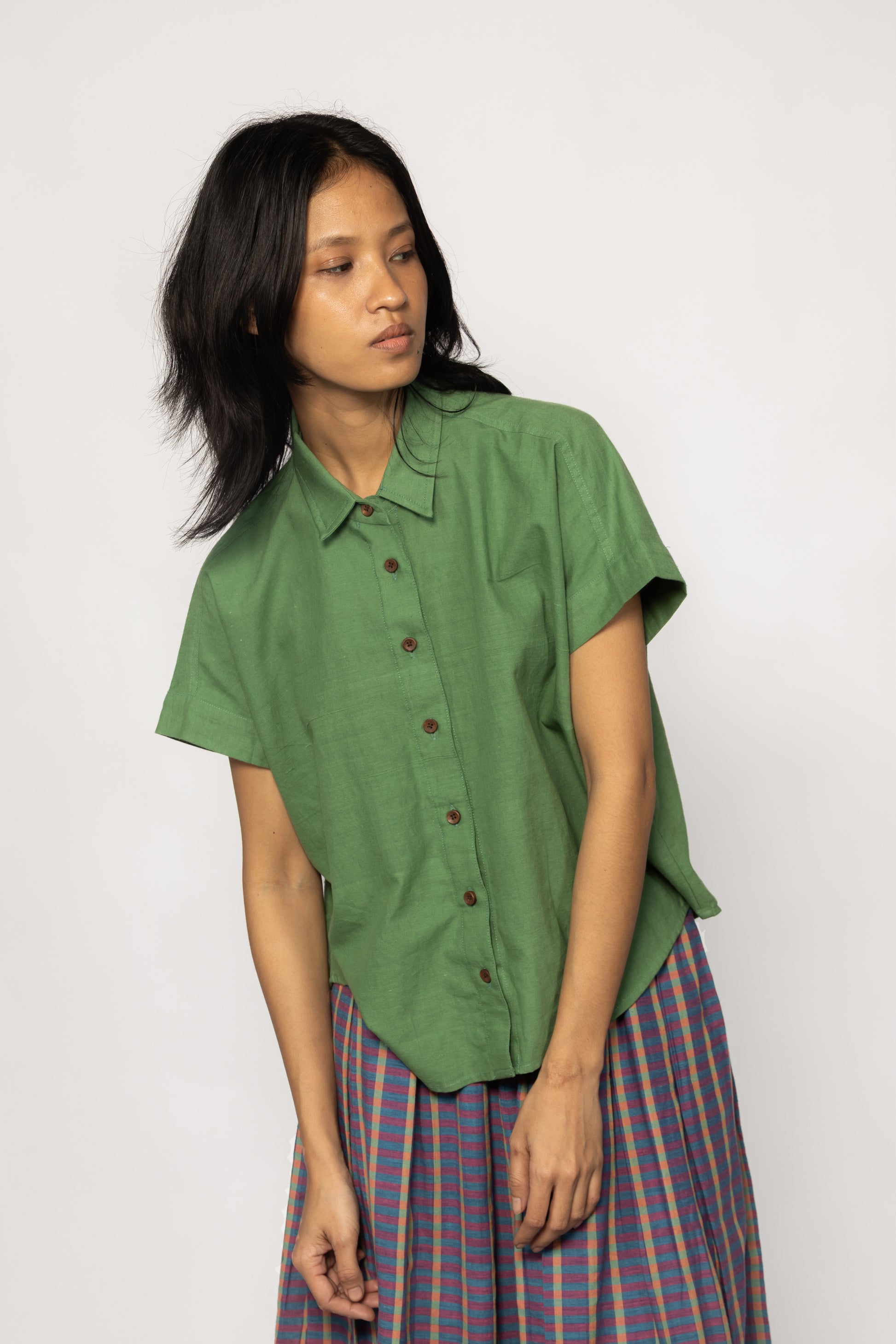 Plains Design - Bud Shirt. Bright green short sleeved shirt with wooden buttons paired with a skirt.