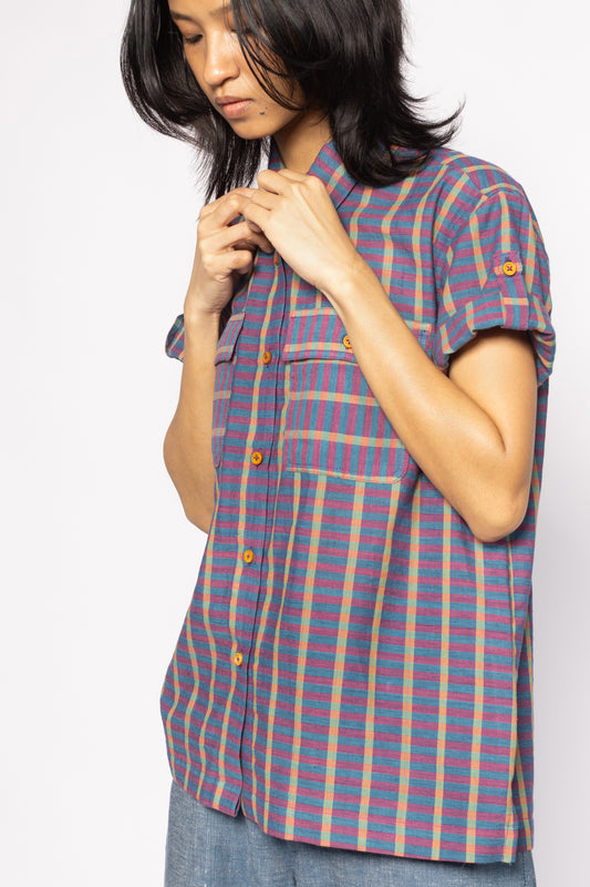 Plains Design - Twin Shirt in Purple. Purple striped button up shirt with pockets on chest and wooden buttons. Short foldable sleeves with buttons. Paired with blue denim pants.